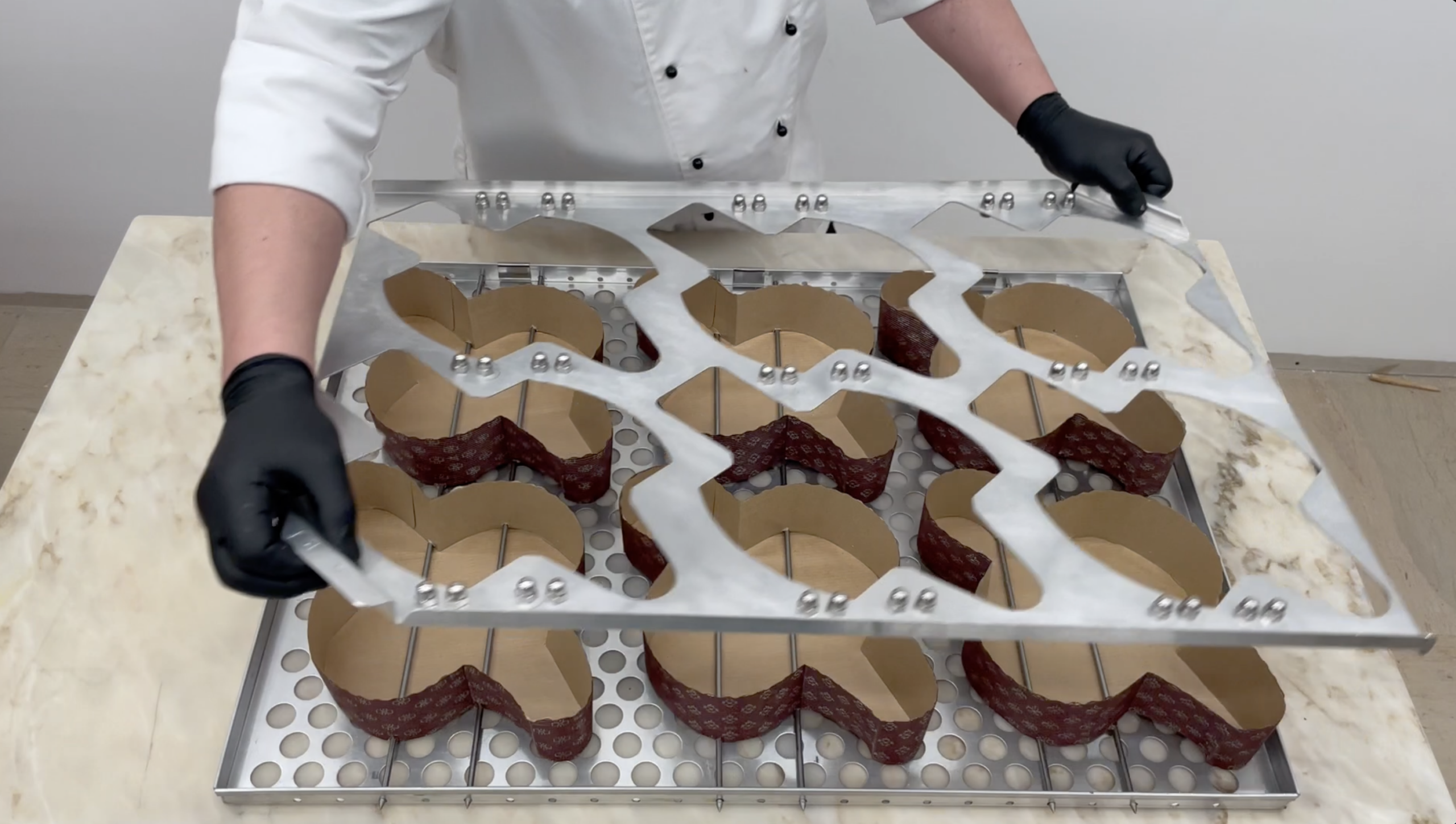 Paper baking mould positioner with jig and skewers on a panettone tray
